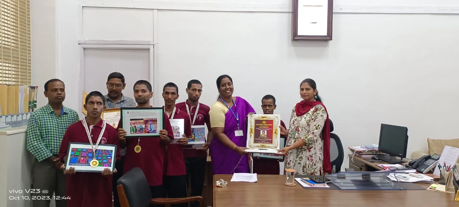 Hope Chennai students in red uniforms showing their framed artwork to officials