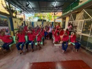 Hope Chennai residents in red shirts cheering together in the courtyard